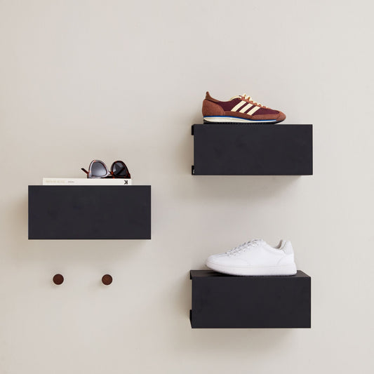 Livsstilsbillede med 3 skohylder i sort, hængende på en væg