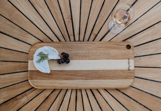 Billede af stort tapasbræt med brie og vindrue på og et glas vin ved siden af