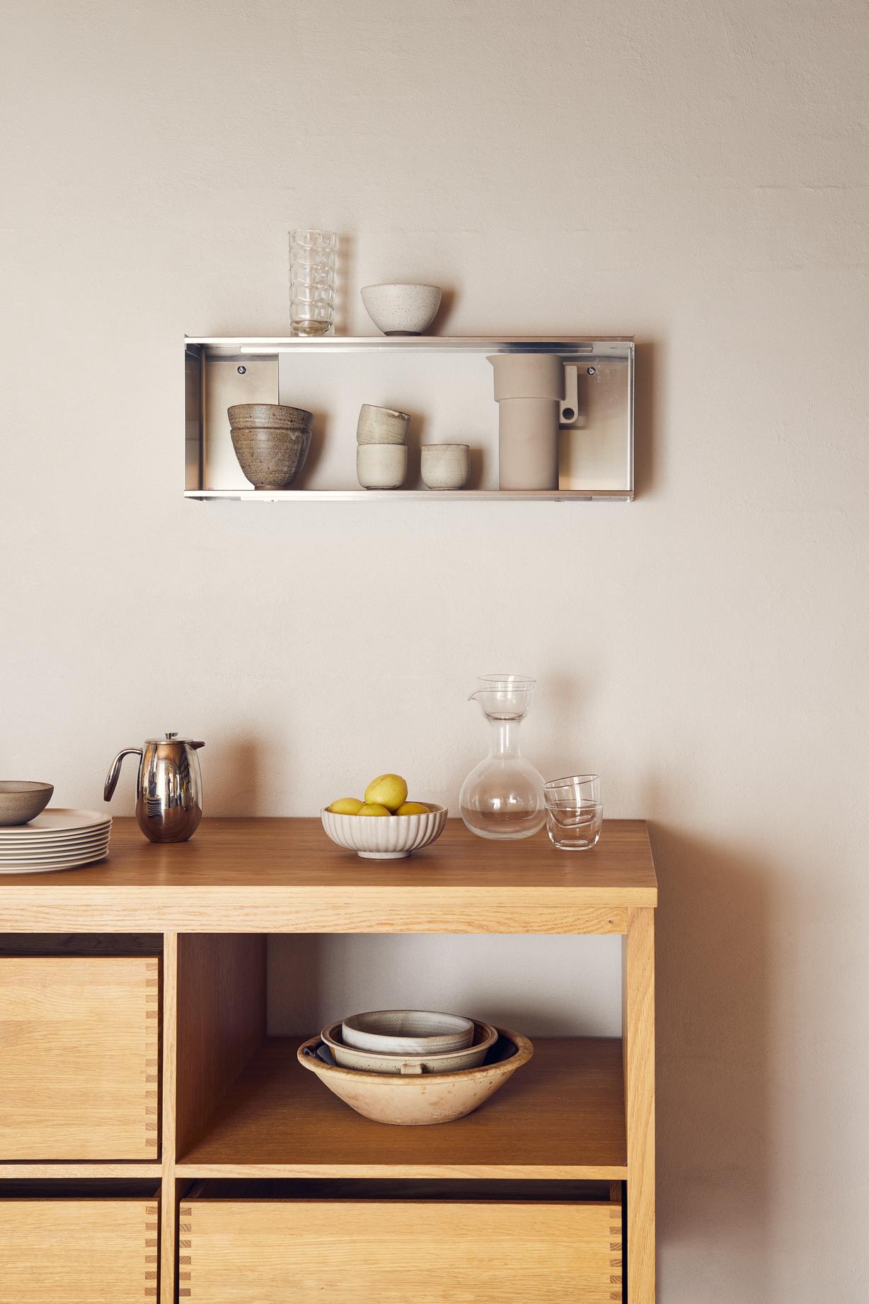 Aflang reol i krom, hænger i køkken med kopper og skål