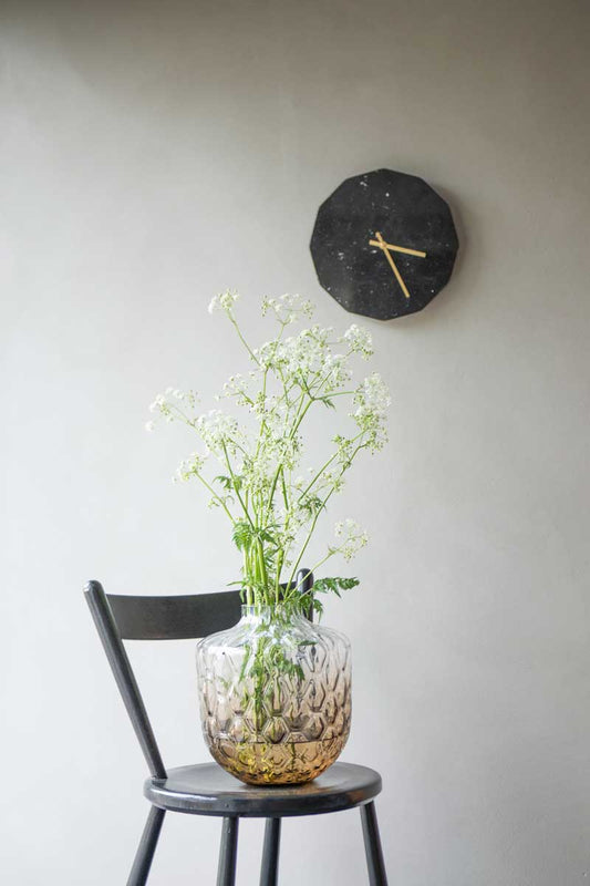 Marmor ur i sort med guld viser 